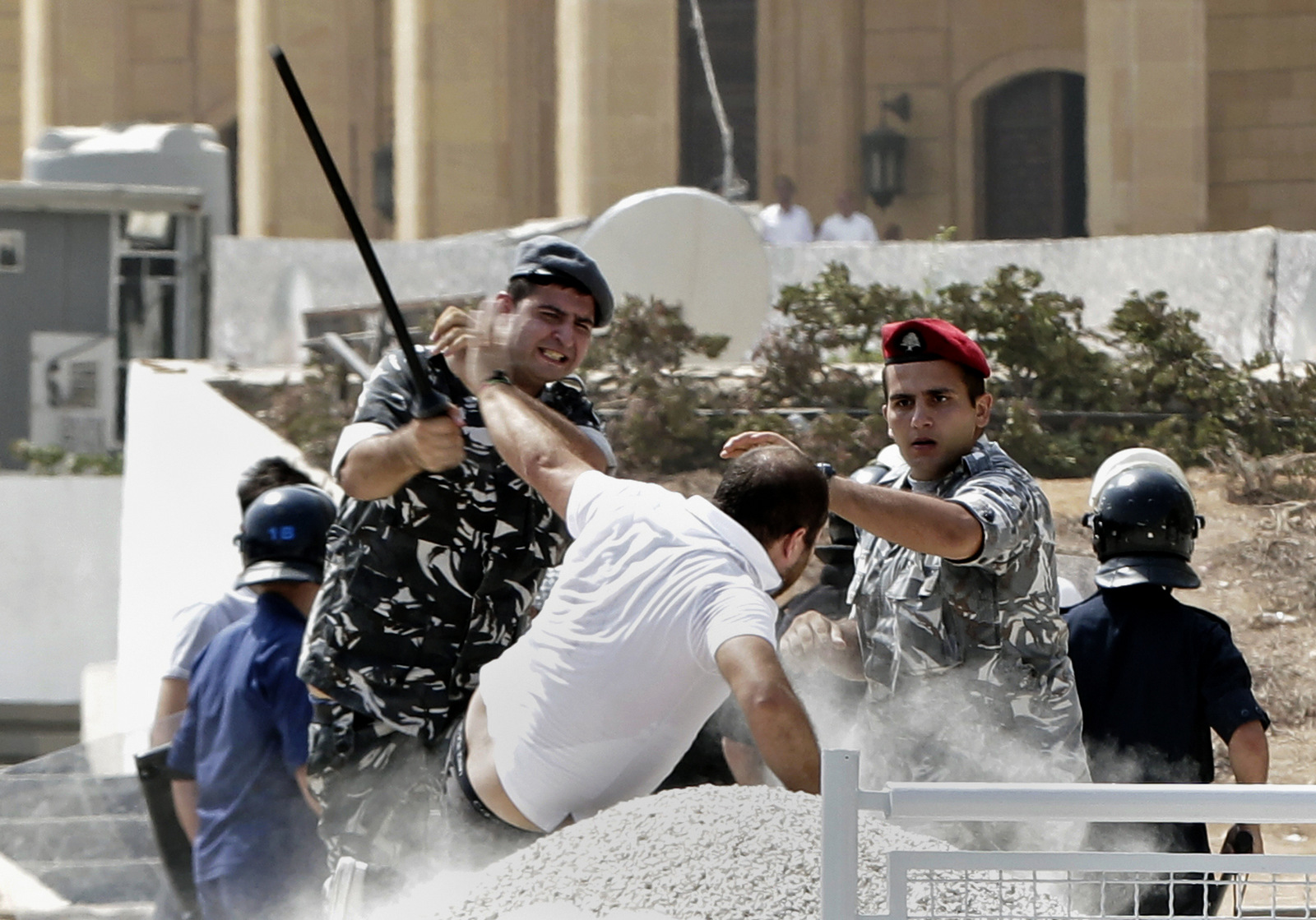 Lebanese riot policemen strike an anti-government protester during clashes on a road leading to the parliament building, in downtown Beirut, Lebanon, Wednesday, Sept. 16, 2015. Lebanese police beat back protesters in downtown Beirut Wednesday ahead of the second session of dialogue between senior politicians, amid widespread anger over the government’s failure to deal with the country’s trash crisis and other political problems. (AP Photo/Bilal Hussein)