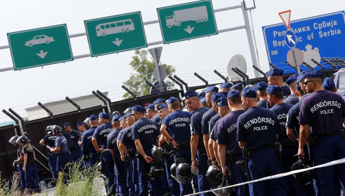 Hungarian police officers gather at main border exit between Serbia and Hungary near Roszke, southern Hungary, Tuesday, Sept. 15, 2015. Hungary are set to introduce much harsher border controls at midnight  laws that would send smugglers to prison and deport migrants who cut under Hungary's new razor-wire border fence. The country's leader was emphatically clear that they were designed to keep the migrants out. (AP Photo/Matthias Schrader)