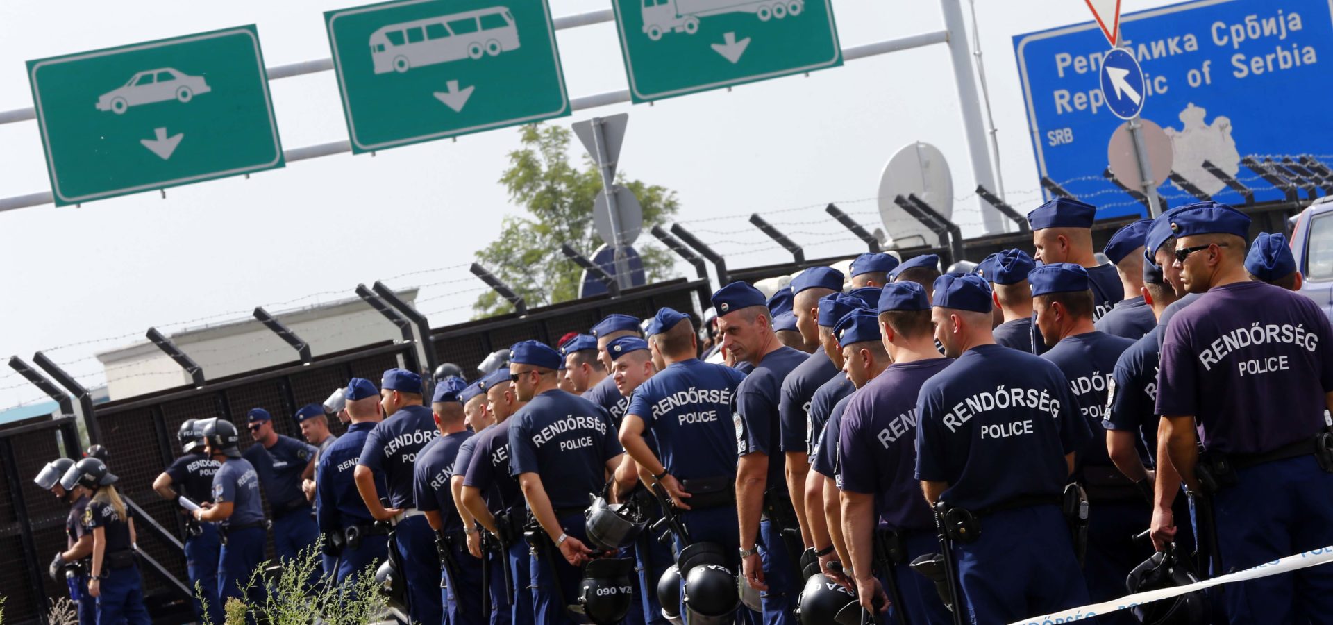 Hungarian police officers gather at main border exit between Serbia and Hungary near Roszke, southern Hungary, Tuesday, Sept. 15, 2015. Hungary are set to introduce much harsher border controls at midnight  laws that would send smugglers to prison and deport migrants who cut under Hungary's new razor-wire border fence. The country's leader was emphatically clear that they were designed to keep the migrants out. (AP Photo/Matthias Schrader)