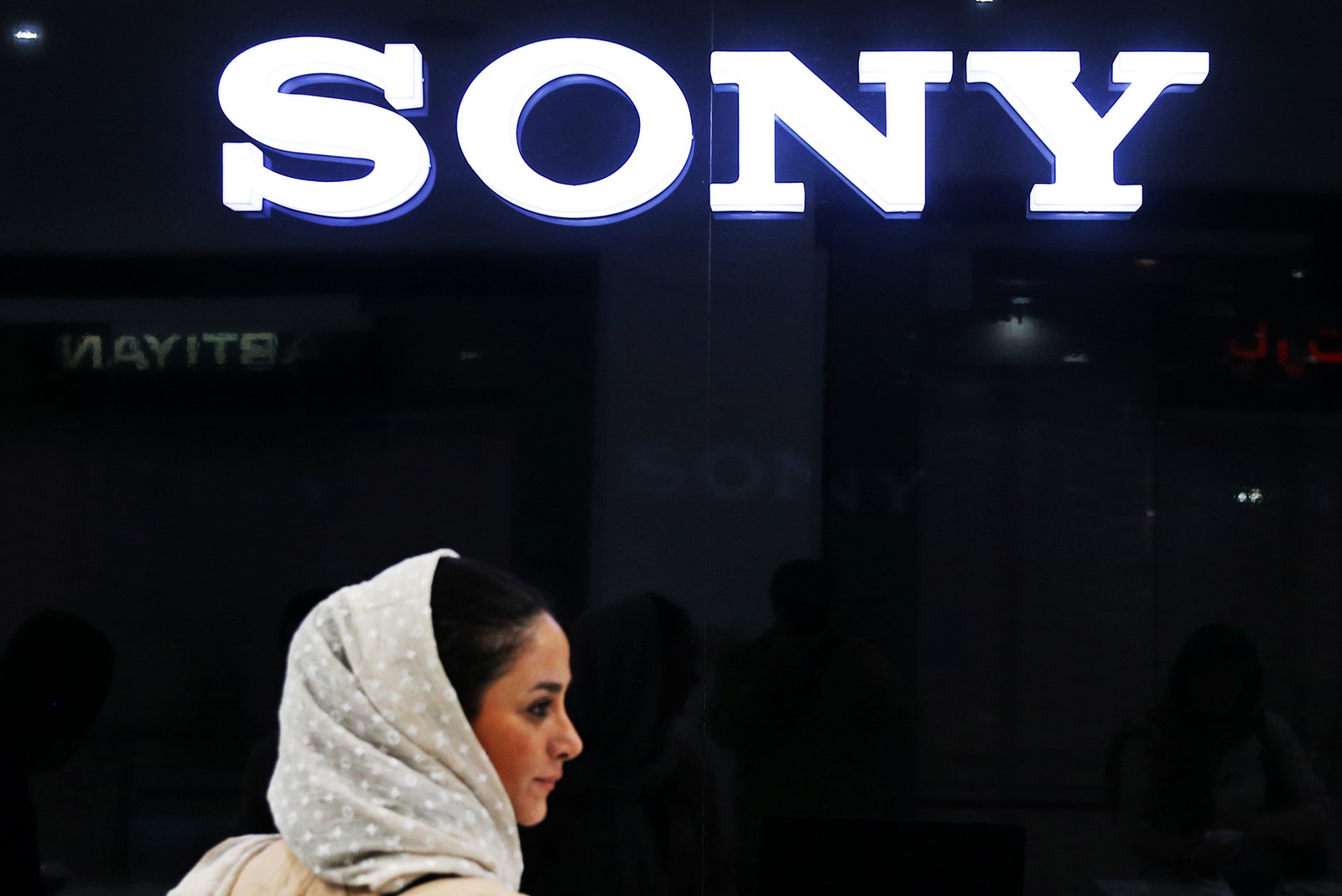 In this picture taken on Friday, July 17, 2015, an Iranian woman walks past a Sony dealer at a shopping center in downtown Tehran, Iran. While it will likely be months before sanctions on Iran ease, business and political leaders are wasting no time in trying to tap into a large and what they hope will be a lucrative Iranian market. Ads for European cars and luxury goods are starting to reappear in Tehran. (AP Photo/Ebrahim Noroozi)