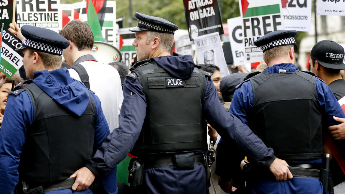 Police officers push back demonstrators during a protest against the visit of Israel's Prime Minister Benjamin Netanyahu to Britain, in front of Downing Street in London, Wednesday, Sept. 9, 2015. (AP Photo/Frank Augstein)