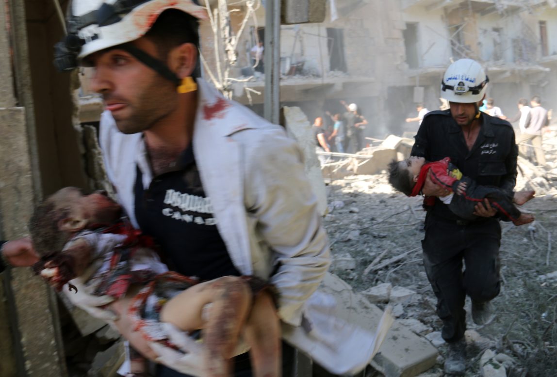 The White Helmets carry the bodies of children following a reported bombardment with explosive-packed "barrel bombs" by Syrian government forces in the al-Mowasalat neighborhood of the northern Syrian city of Aleppo on April 27, 2014.