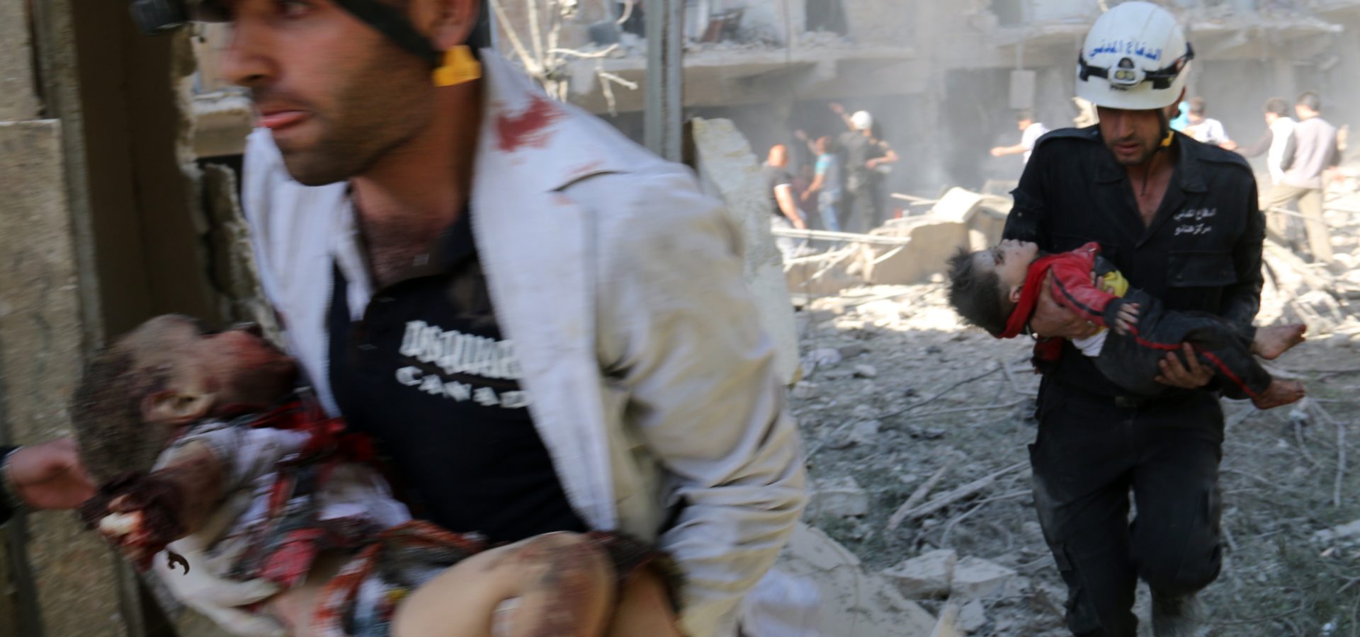 The White Helmets carry the bodies of children following a reported bombardment with explosive-packed "barrel bombs" by Syrian government forces in the al-Mowasalat neighborhood of the northern Syrian city of Aleppo on April 27, 2014.