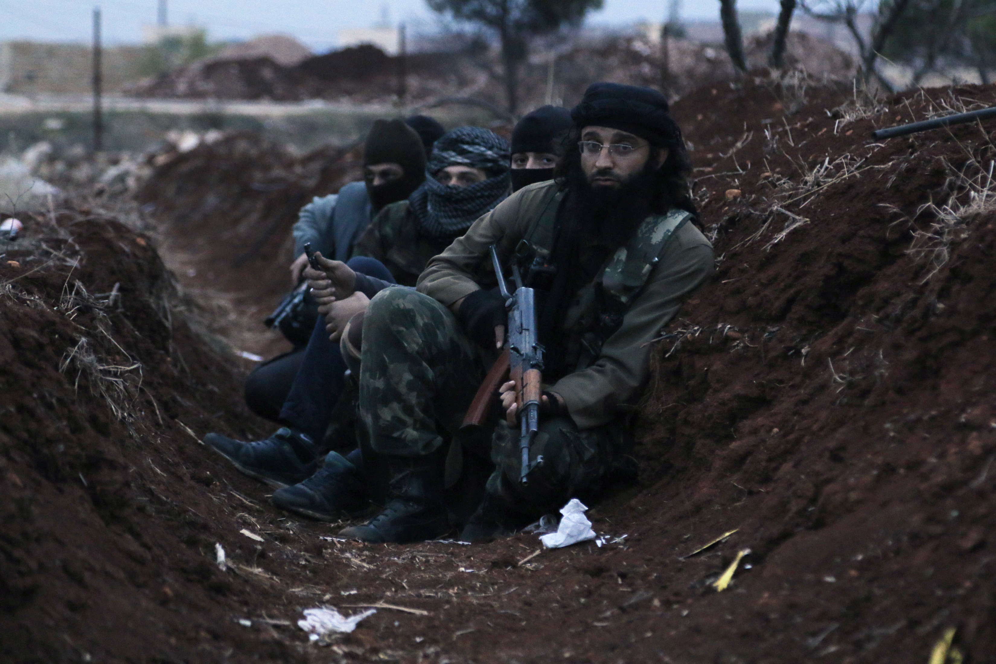 Members of al Qaeda's Nusra Front carry their weapons as they sit in a trench near al-Zahra village, north of Aleppo city, November 25, 2014. (REUTERS/Hosam Katan) 