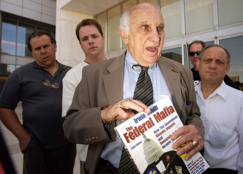 Irwin Schiff holds a copy of his book, ``The Federal Mafia: How It Illegally Imposes and Unlawfully Collects Income Taxes," as he leaves the U.S. Federal Courthouse in Las Vegas, Friday, April, 11, 2003. (AP Photo/Joe Cavaretta)