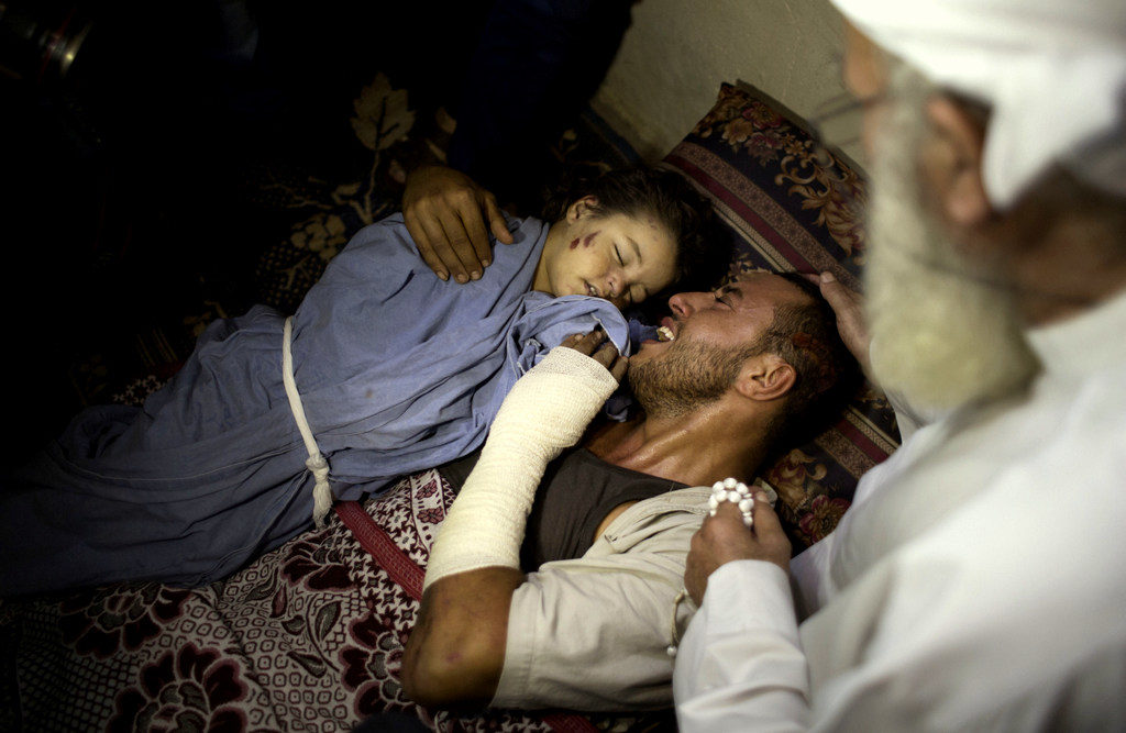 The father of two-year-old, Rahaf Hassan, weeps as he holds her body after she and her 30-year-old mother pregnant mother, Noor Hassan, were killed in Israeli air strike in the Gaza Strip (AP/ Khalil Hamra)