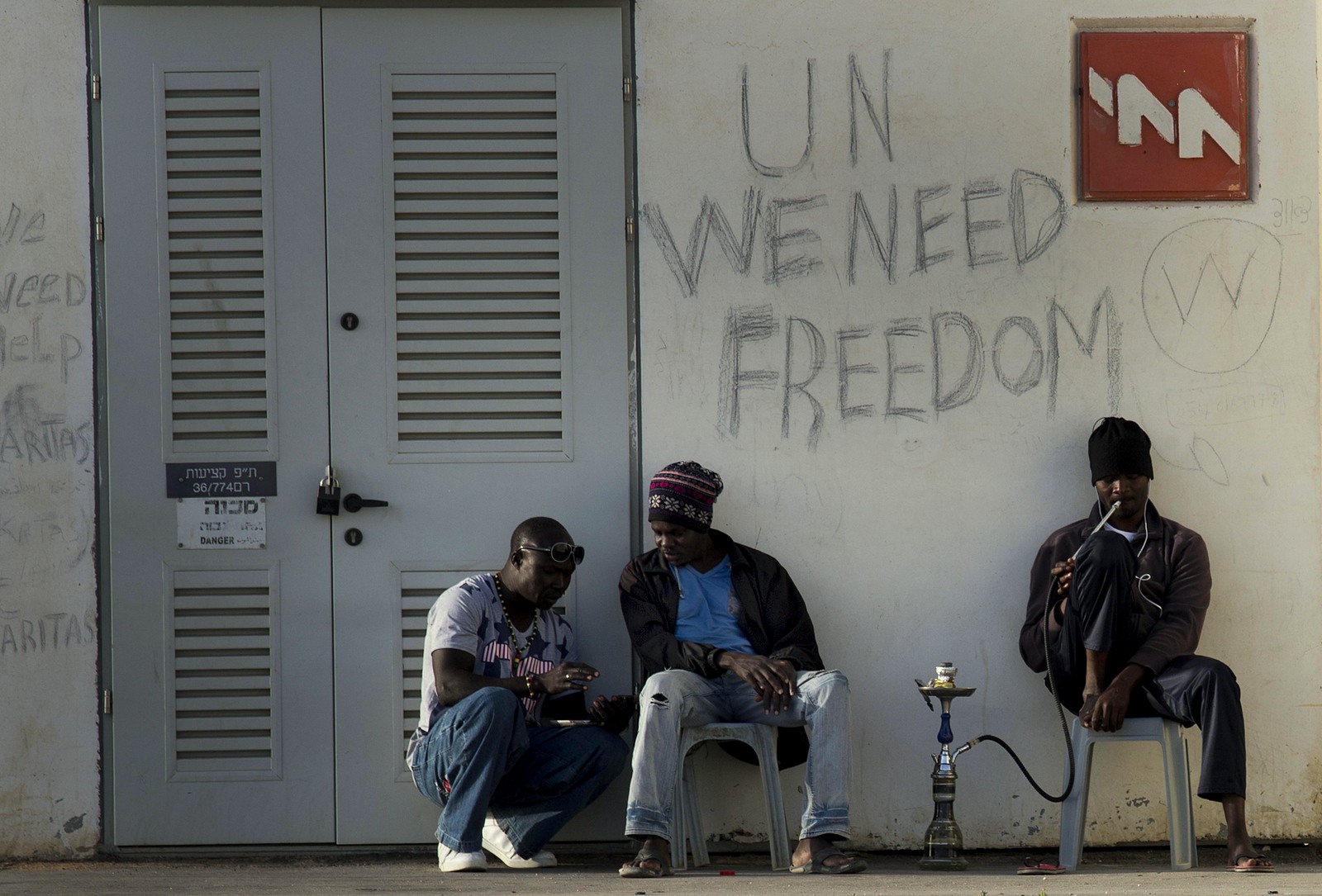 African migrants sit outside Holot detention center in the Negev Desert, southern Israel, Tuesday, April 21, 2015. Tens of thousands of African asylum seekers have made their way to Israel in recent years. Most of them came from Eritrea, an eastern African nation with one of the world’s most dismal human rights records. (AP Photo/Tsafrir Abayov)