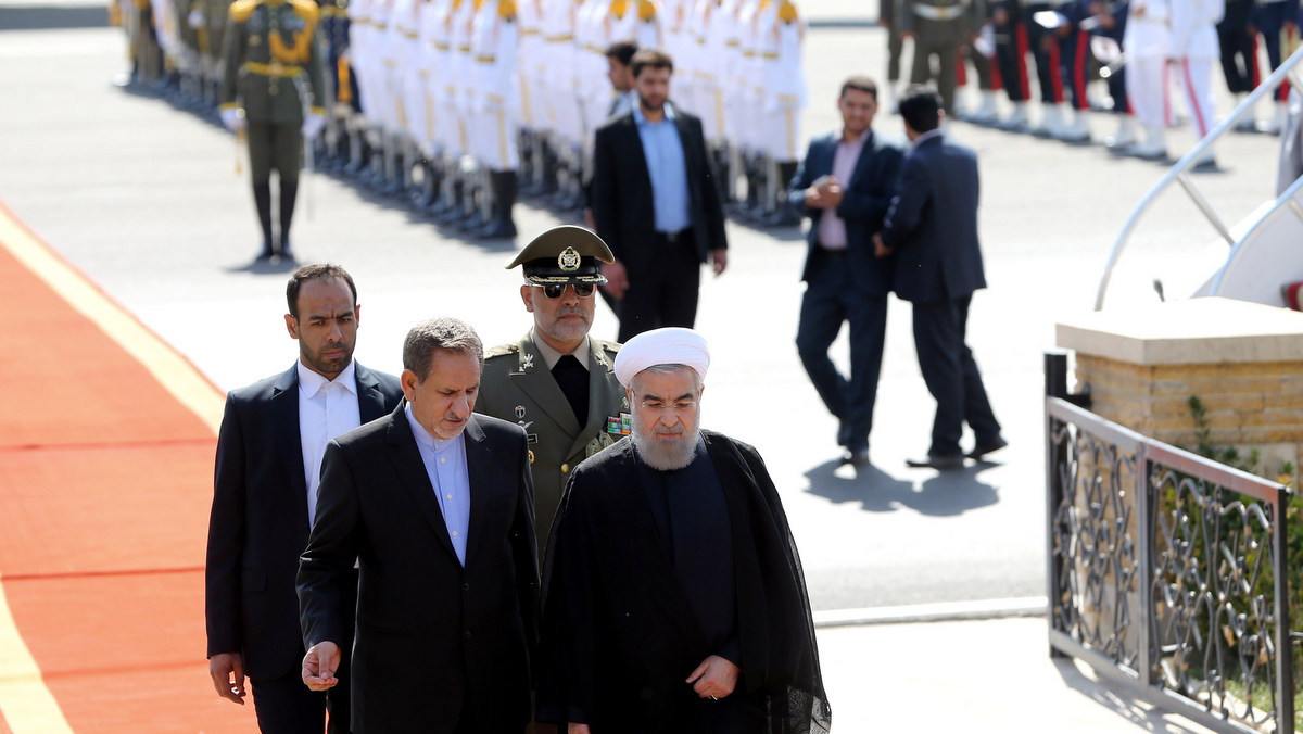 Iranian President Hassan Rouhani, right, walks with Vice President Eshagh Jahangiri, left, upon his arrival from the U.S. at Mehrabad airport in Tehran, Iran, Tuesday, Sept. 29, 2015. Iran’s president says he is ready "to travel anywhere and meet anyone necessary" to stop war and bloodshed in Syria, Iraq and Yemen. (AP Photo/Ebrahim Noroozi)