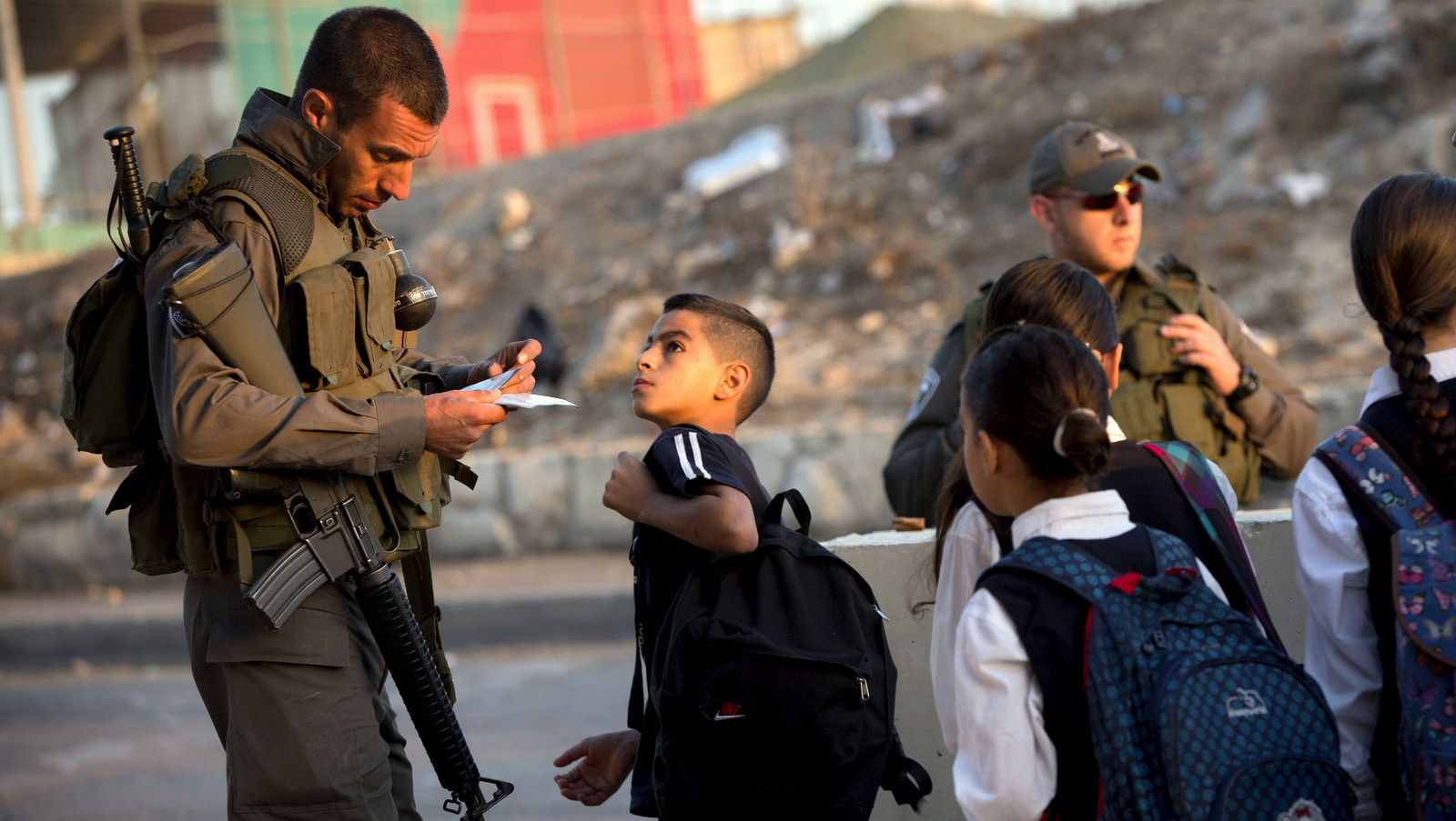 2015年10月22日星期四，以色列边防警察在耶路撒冷的一个检查站检查巴勒斯坦人的身份证。巴勒斯坦右翼团体呼吁人们记住再次引发最近暴力事件的长期占领。 （美联社照片/ Oded Balilty）