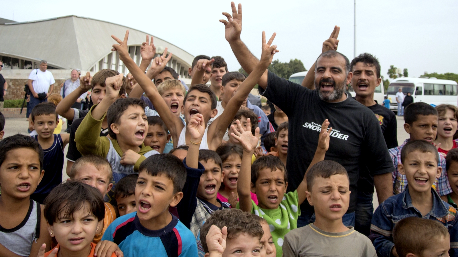 Refugees kids shout "Thank you, Putin!" while posing for journalists at a camp in Latakia, Syria, Friday, Oct. 23, 2015. At a refugee camp in Latakia, which houses several thousand mostly Alawite refugees from other provinces of Syria. (AP Photo/Vladimir Isachenkov)