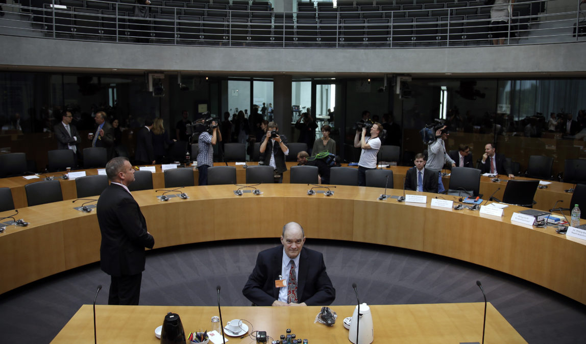 A police officer stands next to former US National Security Agency, NSA, employee William Binney, center, as Binney waits for his questioning by the German parliamentary NSA investigation committee in Berlin, Germany, Thursday, July 3, 2014. The committee investigates the NSA surveillance activities, that also included the tapping of German Chancellor Angela Merkel. (AP Photo/Michael Sohn)