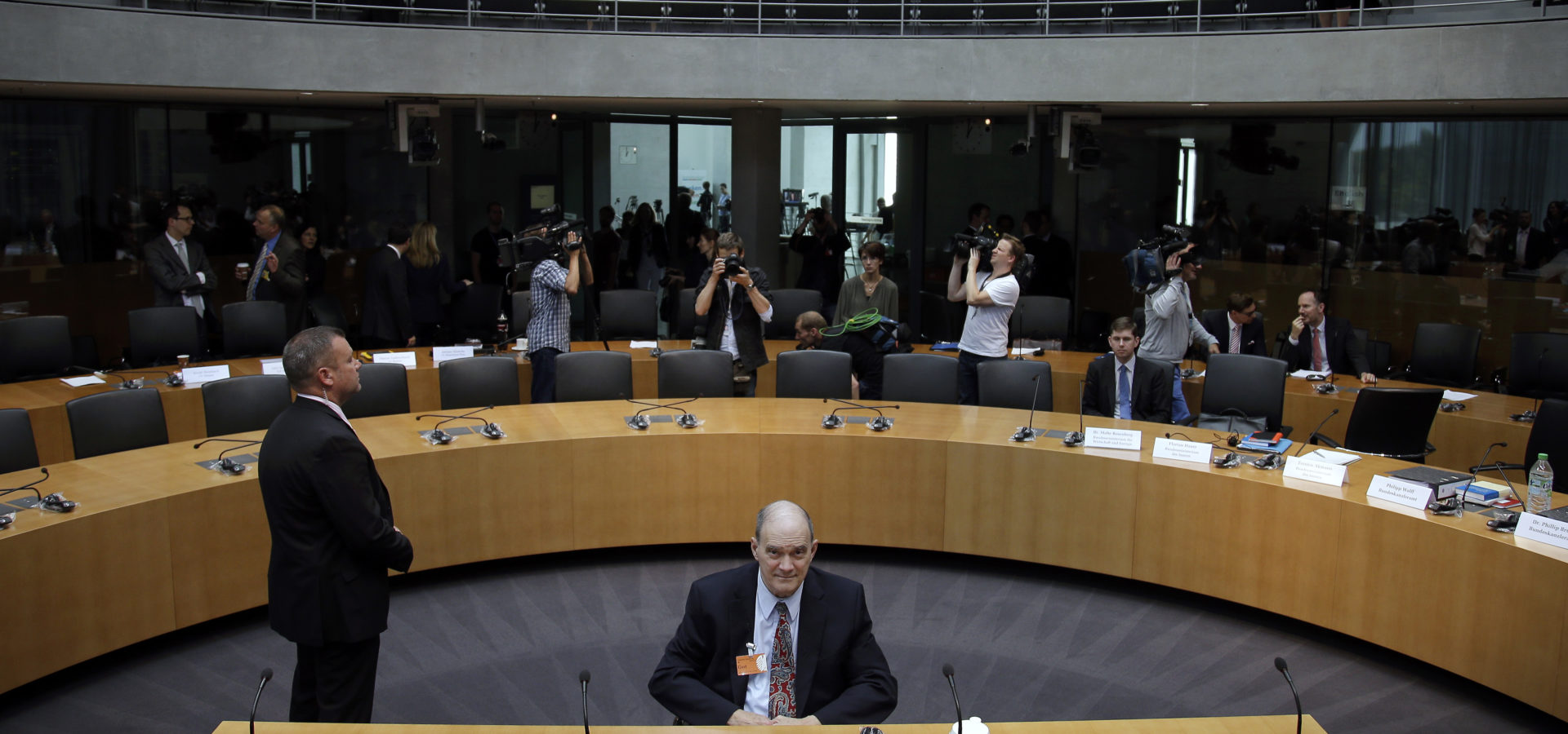 A police officer stands next to former US National Security Agency, NSA, employee William Binney, center, as Binney waits for his questioning by the German parliamentary NSA investigation committee in Berlin, Germany, Thursday, July 3, 2014. The committee investigates the NSA surveillance activities, that also included the tapping of German Chancellor Angela Merkel. (AP Photo/Michael Sohn)