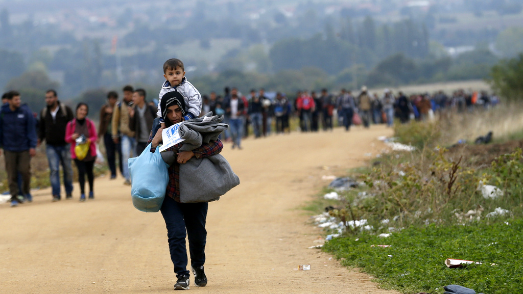 Migrants walk from the Macedonian border into Serbia, near the village of Miratovac, Serbia, Wednesday, Oct. 7, 2015. Several Eastern European countries are cooperating on controlling the flow of migrants at the external borders of the European Union, Zsolt Nemeth, head of the Hungarian parliament's foreign relations committee said Tuesday could set an example for the rest of the 28-nation bloc. (AP Photo/Darko Vojinovic)