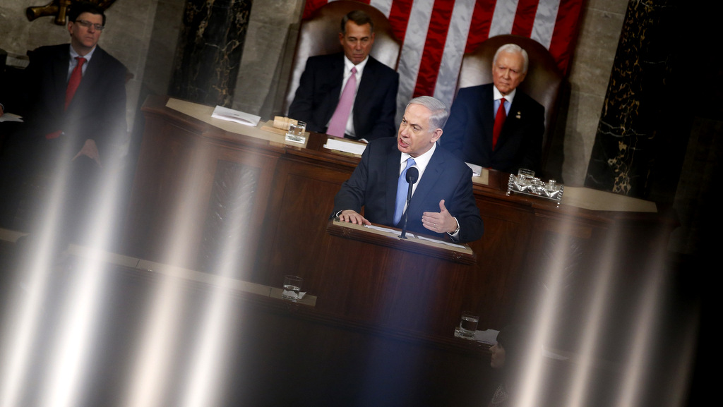 The lights of the House Chamber are reflected in the railing that surrounds the chamber on Capitol Hill in Washington, Tuesday, March 3, 2015, as Israeli Prime Minister Benjamin Netanyahu speaks before a joint meeting of Congress. In a speech that stirred political intrigue in two countries, Netanyahu told Congress that negotiations underway between Iran and the U.S. would "all but guarantee" that Tehran will get nuclear weapons, a step that the world must avoid at all costs. House Speaker John Boehner, of Ohio, left, and Sen. Orrin Hatch, R-Utah, listen. (AP Photo/Andrew Harnik)