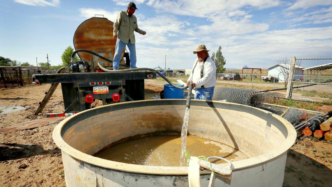 Richard Charley, right, and Melvin Jones deliver water to a ranch along the San Juan River on the Navajo Reservation, Wednesday, Aug. 12, 2015, in Shiprock, NM. Toxic wastewater from the Gold King Mine in Silverton, Colo., has contaminated the San Juan River in Northern New Mexico from the runoff of the Animas River due to an accidental breach by a mining a safety team working for the Environmental Protection Agency last week. A 100-mile-long plume has since traveled for hundreds of miles, through parts of Colorado, New Mexico and Utah on the way to Lake Powell, a key source of water for the Southwest. (AP Photo/Matt York)
