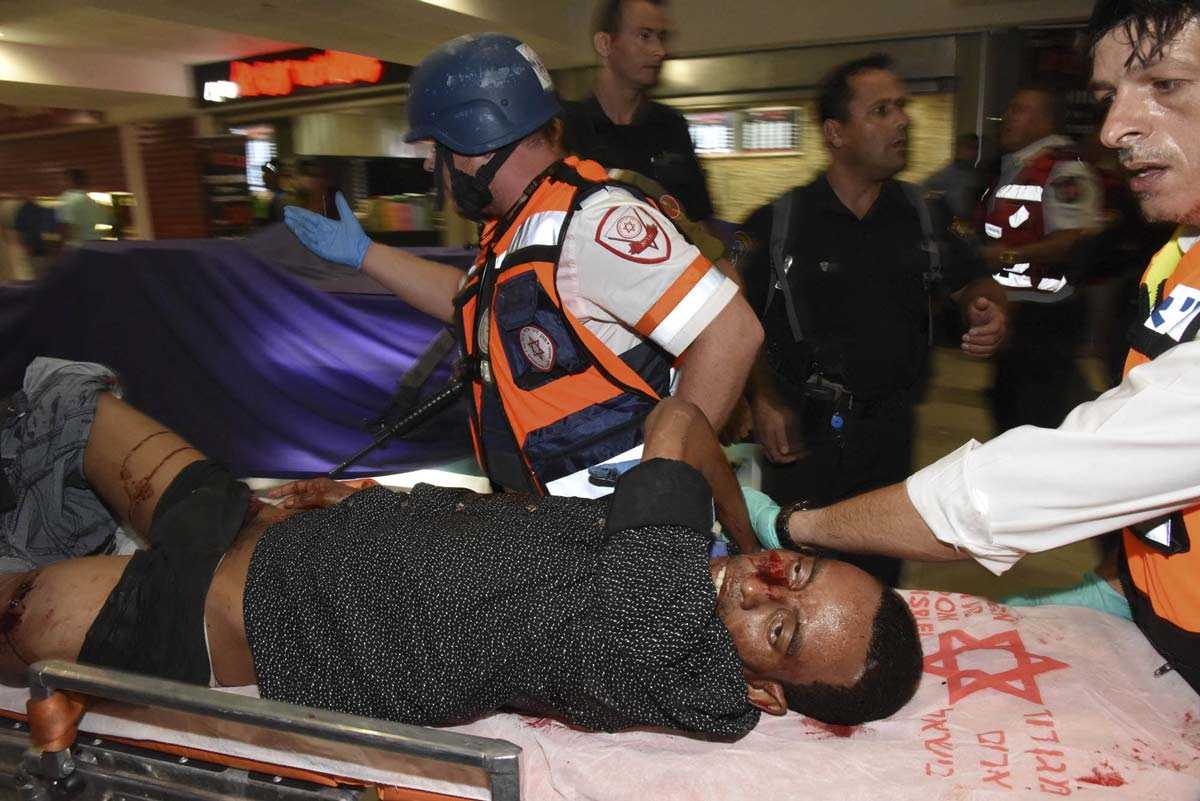 In this Sunday, Oct. 18, 2015 file photo, Mulu Habtom Zerhoma, a wounded Eritrean, is evacuated from the scene of an attack in Beersheba, Israel. (AP Photo/Dudu Grunshpan, File)