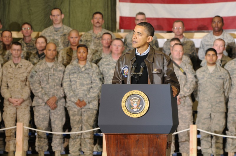 Barack Obama speaks at a podium with the seal of the President of the United States of America in front of a row of soldiers on a surprise visit to Bagram Airfield, Afghanistan on December 3, 2010. (Flickr / DVIDSHUB / David House)
