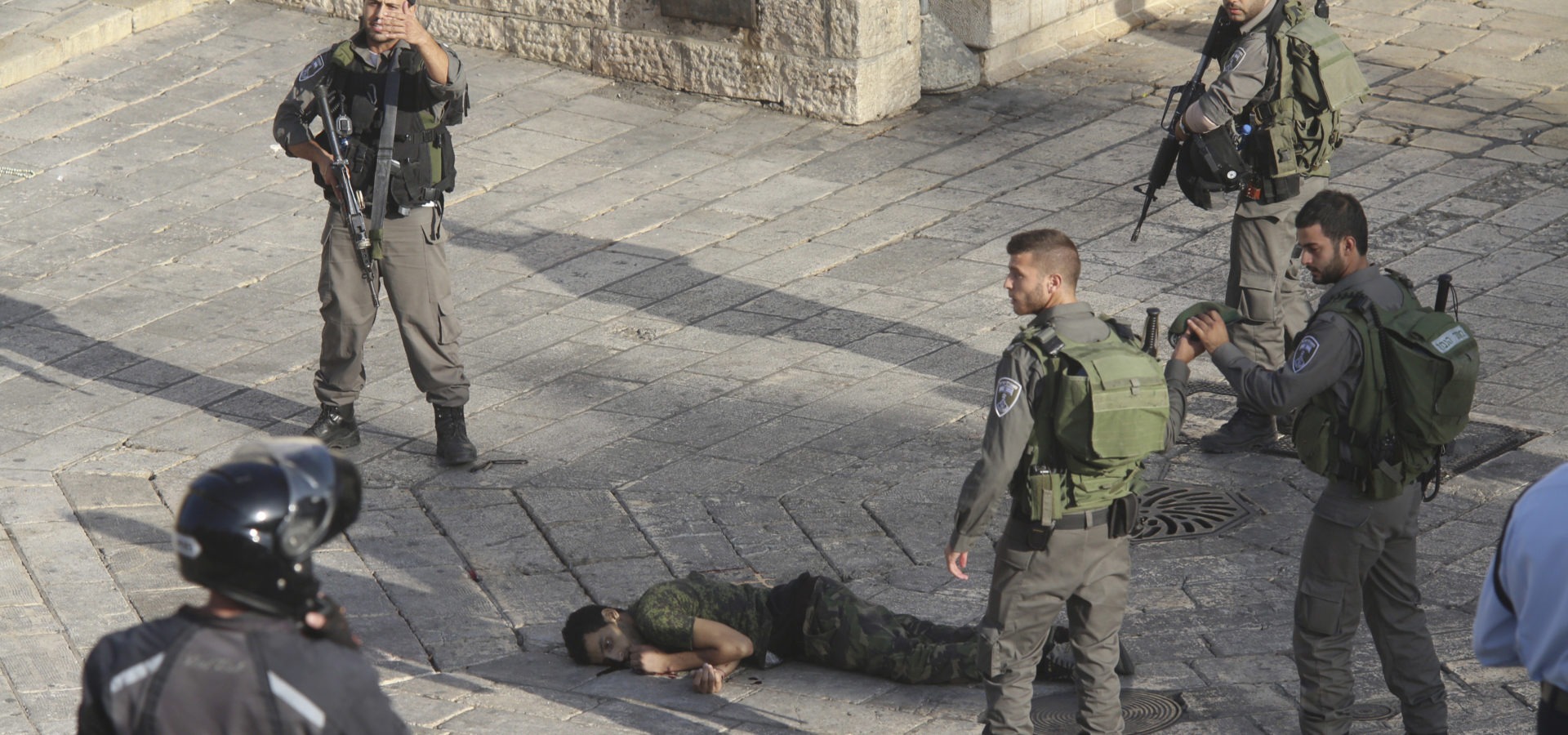 Israeli police stand around a Palestinian shot after he allegedly tried to stab a person at Damascus Gate of the Jerusalem's Old City, Wednesday, Oct. 14, 2015, Israeli police said. (AP Photo/Oren Ziv)