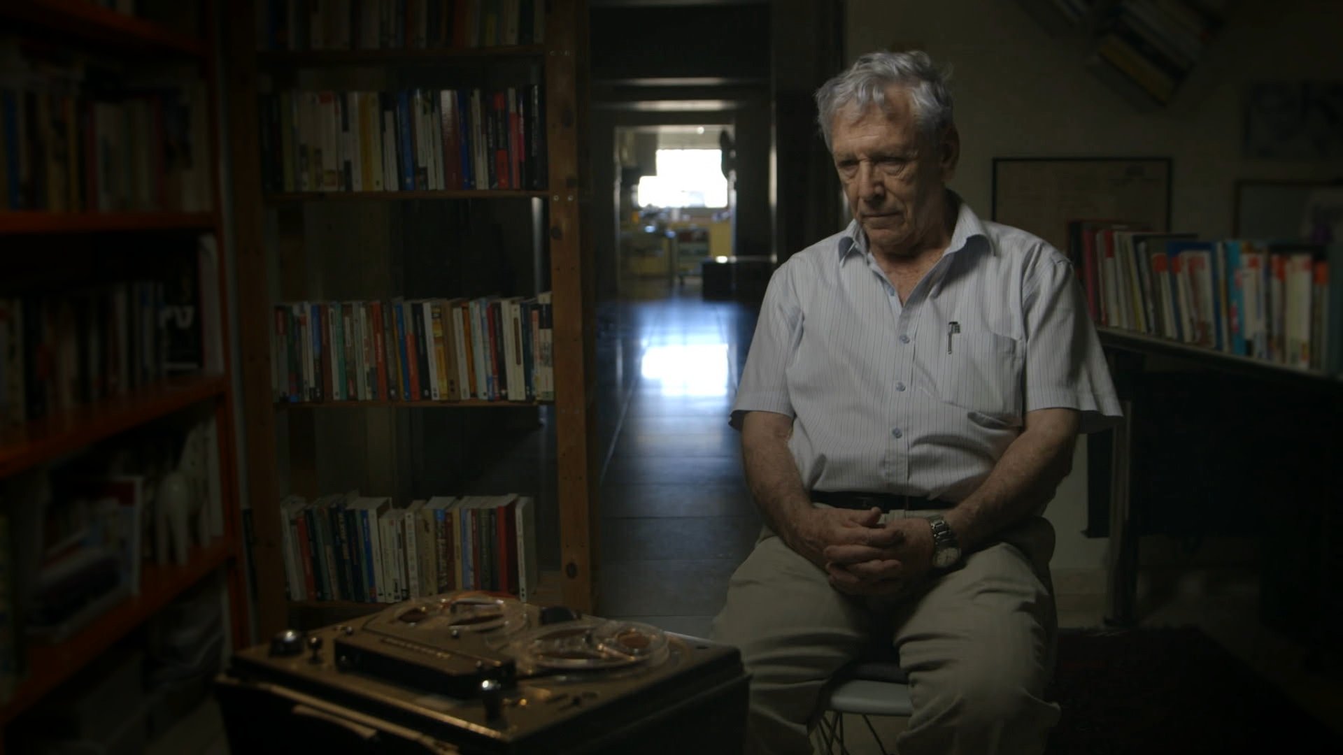 Amos Oz sits infront of one of the tape recorders use to record soldier's testimonies for the documentary film, Censored Voices.