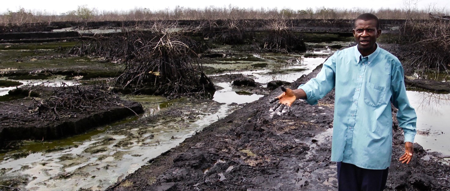 Pastor Christian Lekoya Kpandei showing the damage done to his fish farm in Bodo, Nigeria, May 2011. Photo credit: Amnesty International