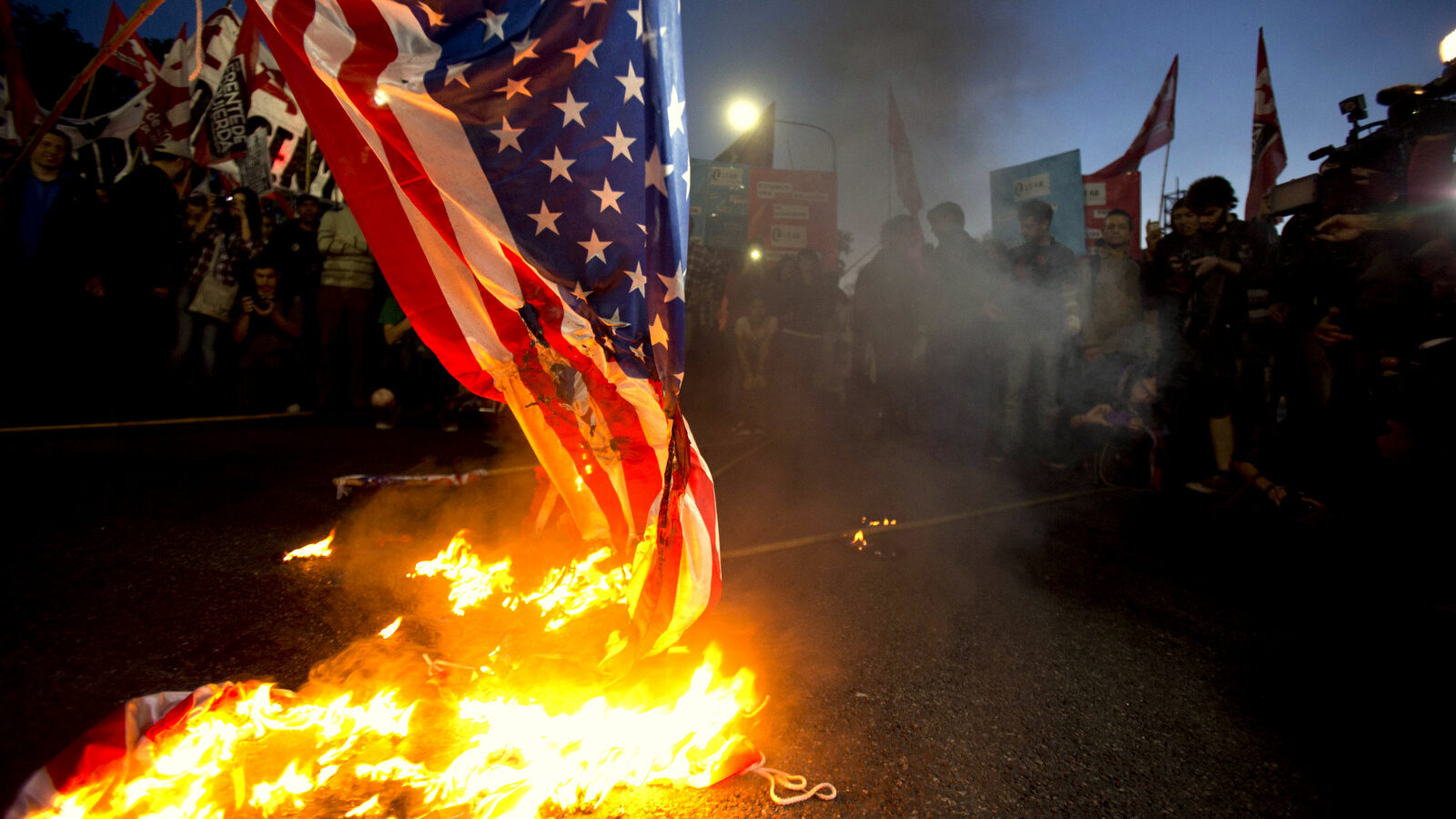 Demonstrators burn a U.S. flag in front of the U.S. embassy in Buenos Aires, Argentina. (AP/Natacha Pisarenko)
