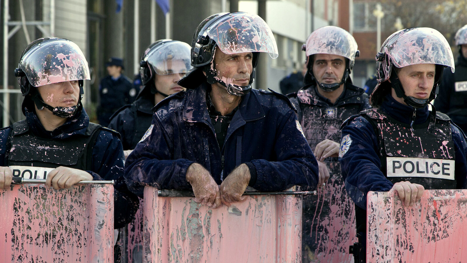 Kosovo police in riot gear are seen covered in pink paint after clashes outside Kosovo parliament building in the capital Pristina on Tuesday, Nov. 17, 2015. Kosovo opposition used tear gas and pepper spray inside parliament and pelted police with rocks and pink paint outside the building in another attempt to force the government to renounce recent deals with Serbia and Montenegro.(AP Photo/Visar Kryeziu)