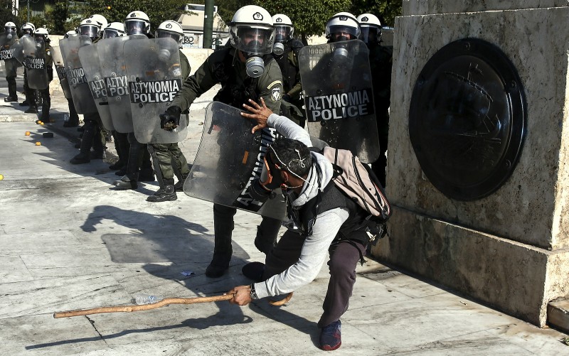 A farmer tries to protect himself as he clashes with a riot policeman during an anti-government protest at central Syntagma square in Athens, Wednesday, Nov. 18, 2015. Greek farmers protesting over planned tax and pension reforms demanded by the country's bailout creditors have clashed outside parliament with police, who used tear gas to disperse them. (AP Photo/Yorgos Karahalis)