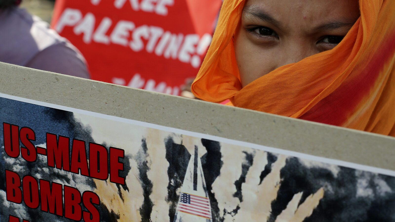 A Filipino activist holds a slogan during a rally in observance of the International Day of Solidarity with the Palestinian People in front of the U.S. Embassy in Manila, Philippines Sunday, Nov. 29, 2015. (AP Photo/Aaron Favila)