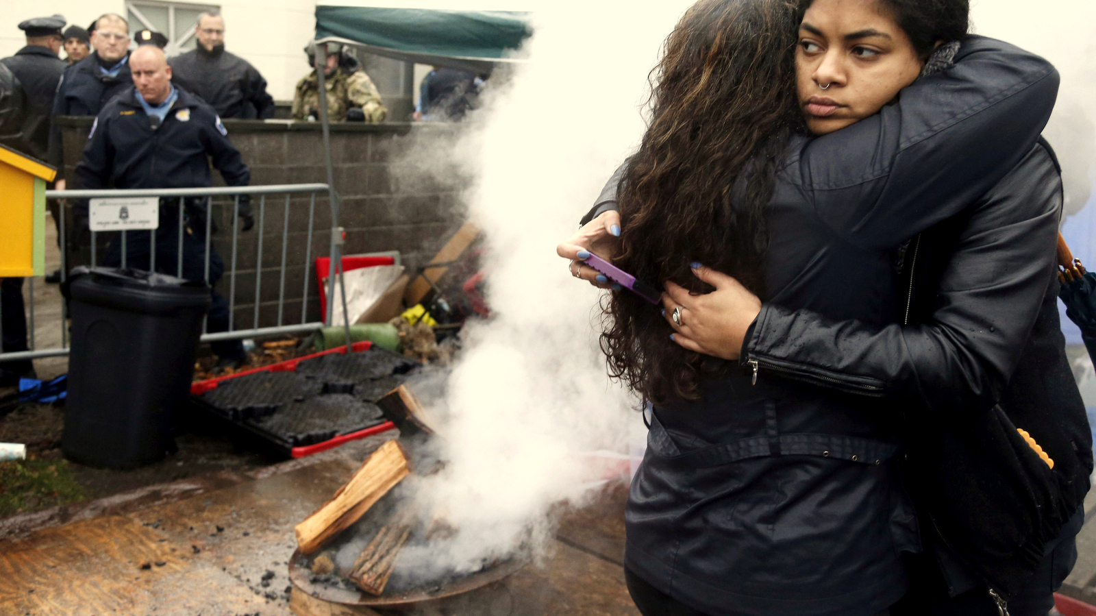 Black Lives Matter supporters embrace after Minneapolis police poured water to extinguish an encampment fire as they continued their protest, Wednesday, Nov. 18, 2015, outside the Fourth Precinct in Minneapolis. The fatal shooting of Jamar Clark, an unarmed black man by a Minneapolis police officer, has pushed racial tensions in the city's small but concentrated minority community to the fore, with the police precinct besieged by a makeshift encampment and many protesters. (AP Photo/Jim Mone)