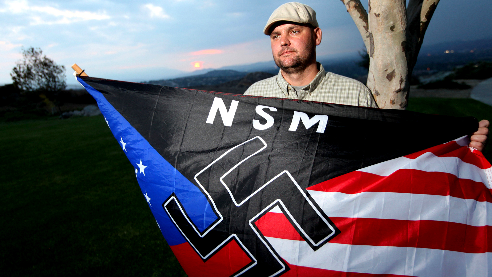 FILE - In this Oct. 22, 2010 file photo, Jeff Hall holds a Neo Nazi flag while standing at Sycamore Highlands Park near his home in Riverside, Calif. On Tuesday, Oct. 30, 2012. (AP Photo/Sandy Huffaker)