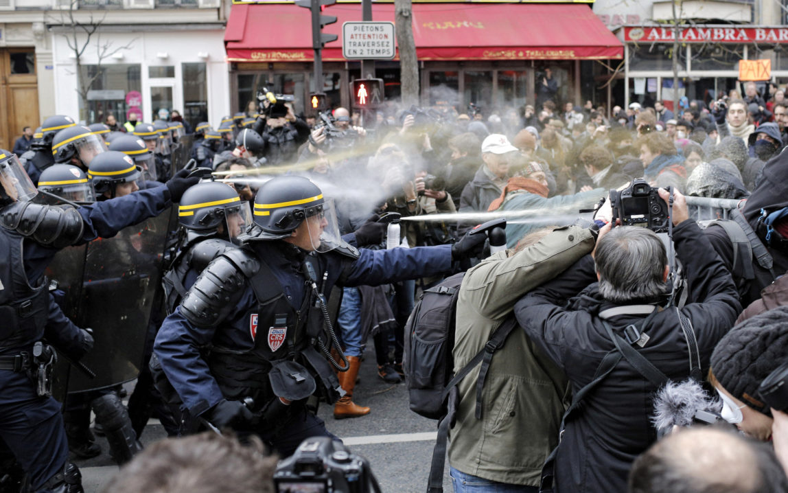 Policemen fight with activists during a protest ahead of the 2015 Paris Climate Conference at the place de la Republique, in Paris, Sunday, Nov. 29, 2015. More than 140 world leaders are gathering around Paris for high-stakes climate talks that start Monday, and activists are holding marches and protests around the world to urge them to reach a strong agreement to slow global warming. (AP Photo/Laurent Cipriani)