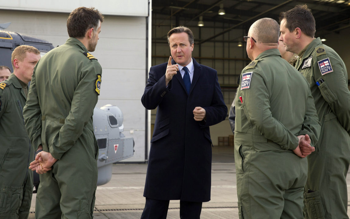 British Prime Minister David Cameron, centre, talks with Royal Navy personnel during his visit to Royal Air Force station RAF Northolt, in west London on Monday Nov. 23, 2015. (Justin Tallis, Pool/AP)