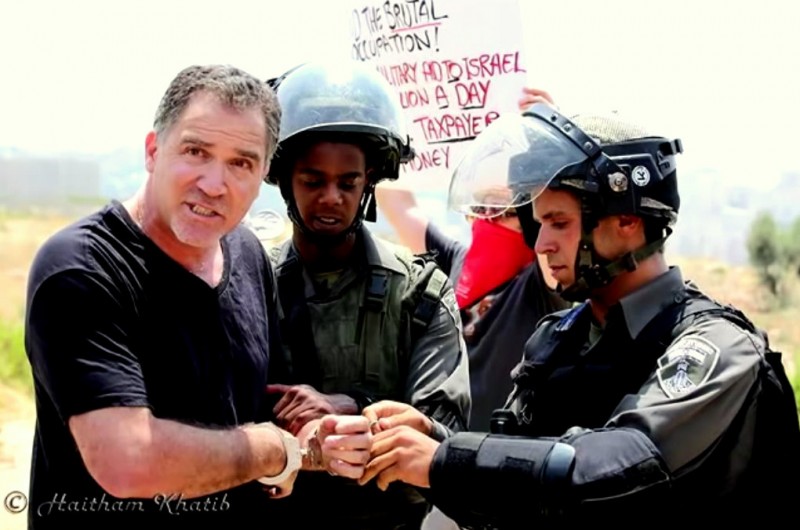 Israeli activist Mike Peled in handcuffs during a protest in Palestine.