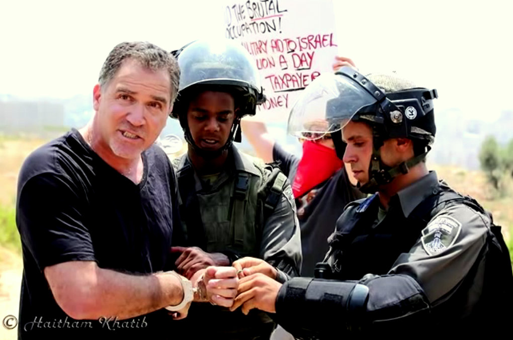 Israeli activist Mike Peled in handcuffs during a protest in Palestine.