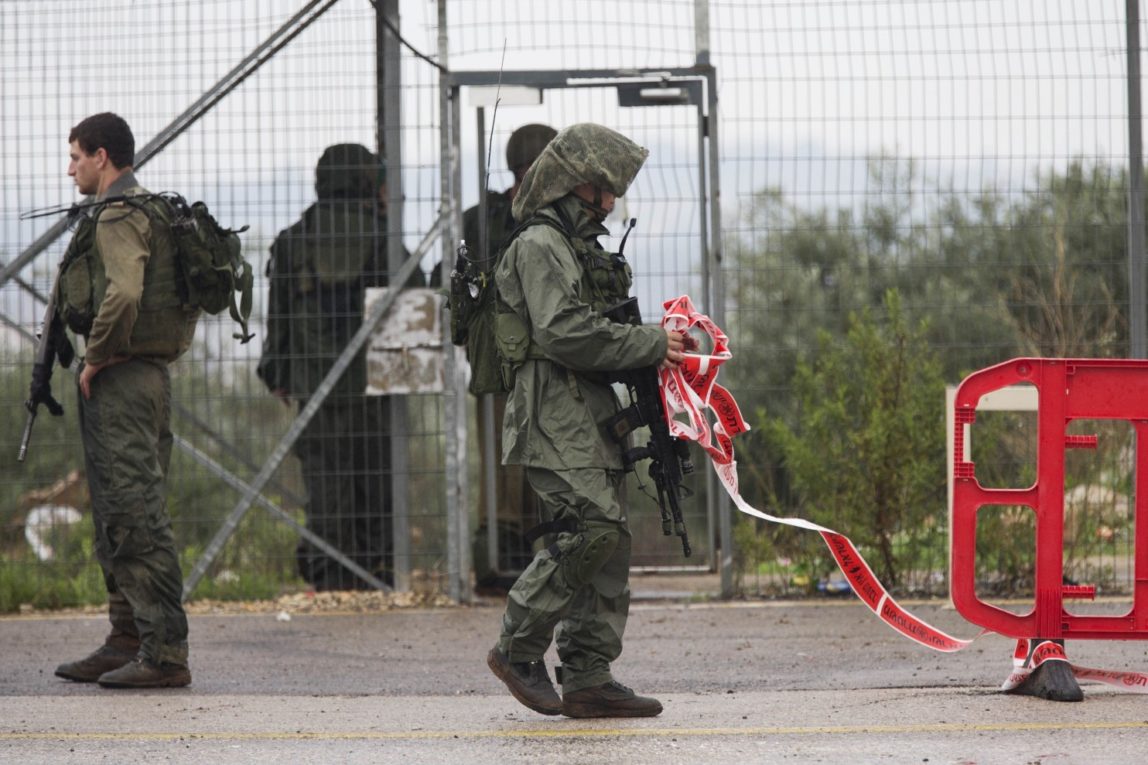 Israeli occupation soldiers clear a road after a Palestinian woman was shot dead at a check point near the West Bank Palestinian town of Qalqilya, Monday, Nov. 9, 2015. (AP Photo/Ariel Schalit)