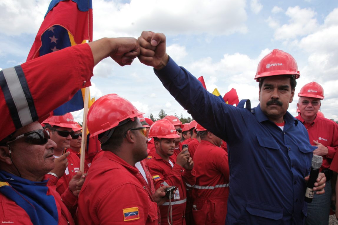 Venezuelan President Nicolas Maduro fist bumps a worker of the state-run oil company PDVSA during a visit to the Orinoco oil belt in Venezuela in 2013. Miraflores Presidential Office/AP/File