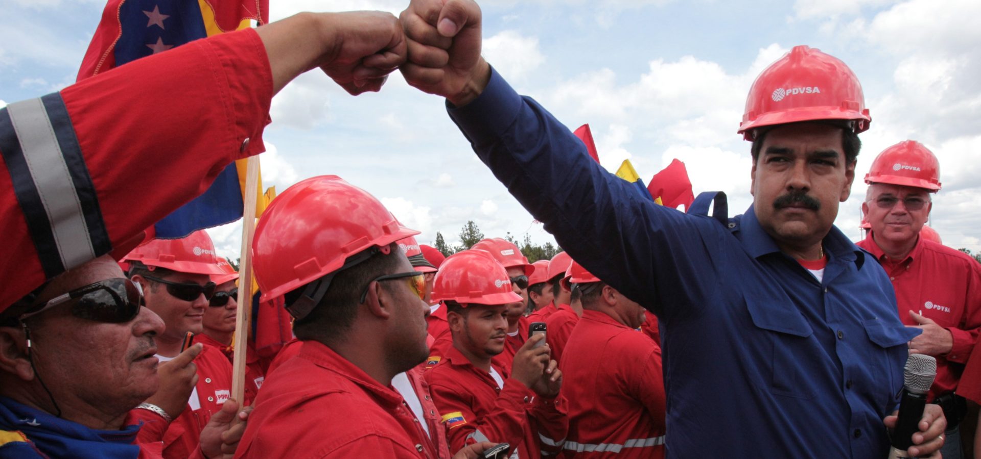 Venezuelan President Nicolas Maduro fist bumps a worker of the state-run oil company PDVSA during a visit to the Orinoco oil belt in Venezuela in 2013. Miraflores Presidential Office/AP/File