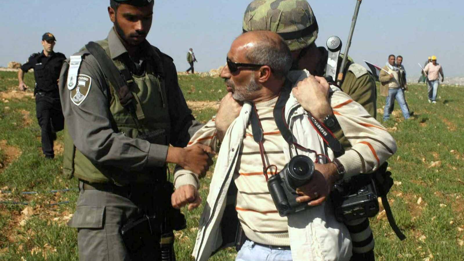 Israeli troops arrest Associated Press photographer Nasser Shiyoukhi during a Palestinian protest in Yatta in the West Bank. Shiyoukhi was later released without charge. (AP Photo)