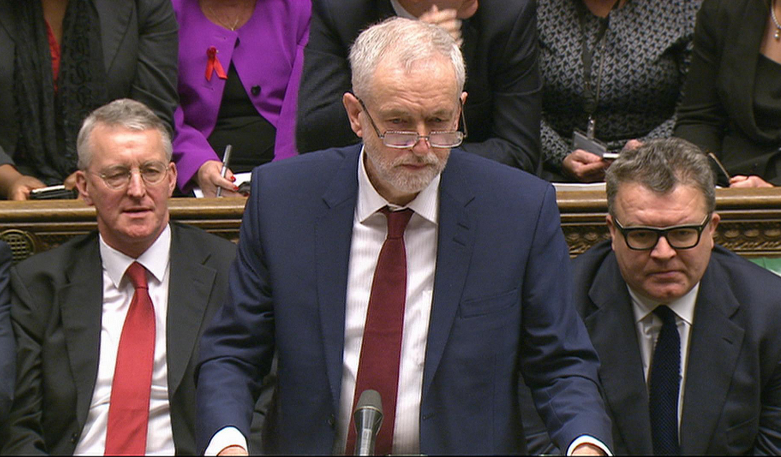 Opposition Labour Party leader, Jeremy Corbyn, centre, stands as he makes a speech to lawmakers inside the House of Commons in London, during a debate on launching airstrikes against ISIS extremists inside Syria, Wednesday, Dec. 2, 2015. Shadow Foreign Secretary Hilary Ben sitting left, and Labour Party Deputy leader Tom Watson, right. The parliamentary vote is expected Wednesday evening. (Parliamentary Recording Unit via AP Video) 