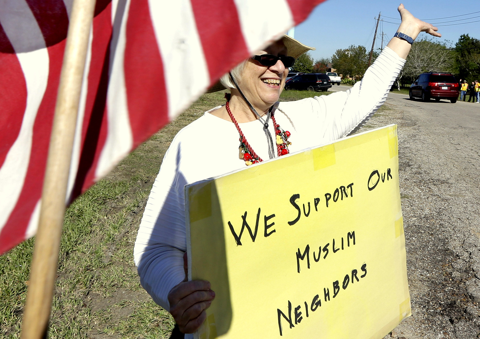 Jane Malin holds a sign as she waves to passing cars during a rally to show support for Muslim members of the community. (AP Photo/David J. Phillip)