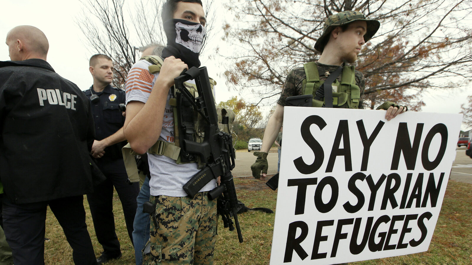 As police stand guard, armed anti-Muslim protestors, who did not want to give their names, stand across the street from a mosque during a demonstration in Richardson, Texas, on Saturday, Dec. 12, 2015. (AP Photo/LM Otero)