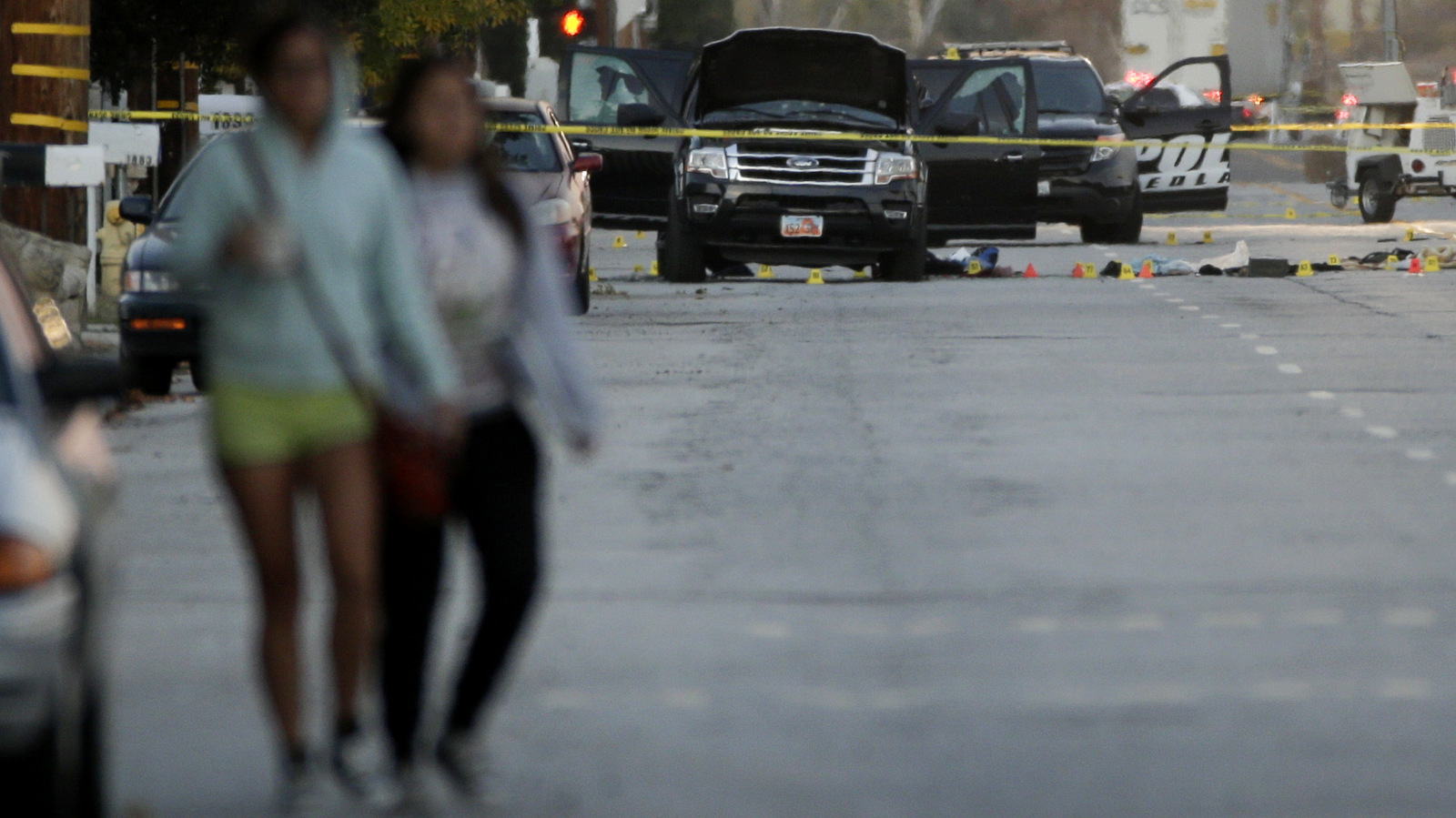 Two residents walk along the street where a police shootout with suspects took place, Thursday, Dec. 3, 2015, in San Bernardino, Calif. (AP Photo/Jae C. Hong)