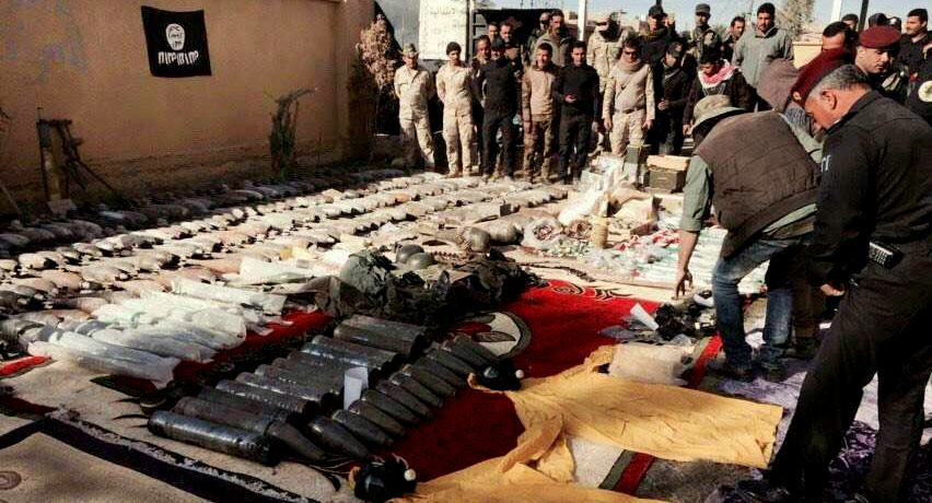 Iraqi security forces look at confiscated ISIS weapons and ammunition after regaining control over the last week, in Ramadi, Iraq's Anbar province, 70 miles (115 kilometers) west of Baghdad, Thursday, Dec. 10, 2015.