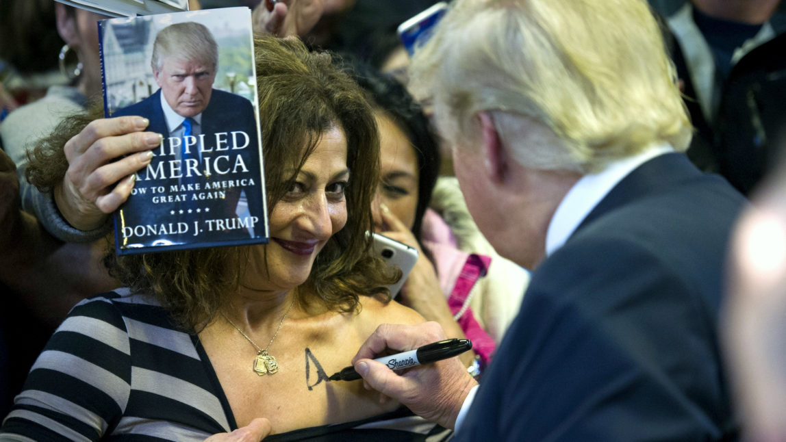 Republican presidential candidate Donald Trump autographs a supporter's chest following his speech at a campaign rally at the Prince William County Fair Ground, Wednesday, Dec. 2, 2015, in Manassas, Va. (AP Photo/Cliff Owen)
