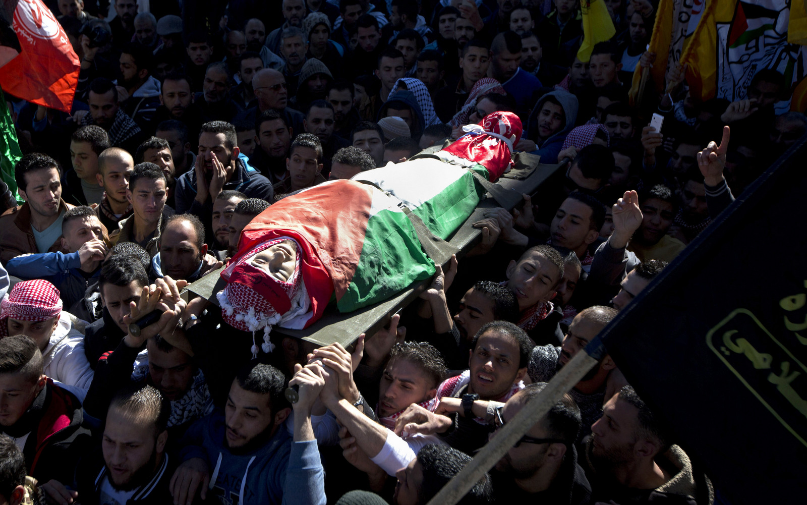 Palestinian mourners carry the body of Malik Shaheen, 21, who was killed by Israeli troops in Deheishe refugee camp near Bethlehem, near the West Bank city of Bethlehem, Tuesday, Dec. 8, 2015. (AP Photo/Majdi Mohammed)