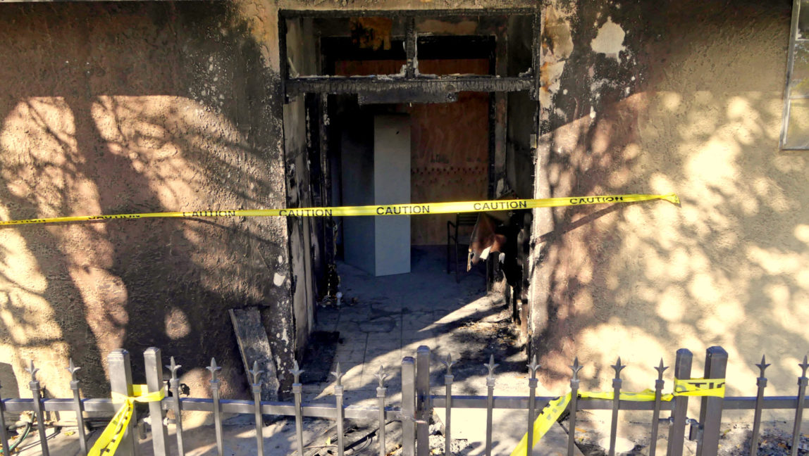 Police tape marks off the burned front lobby of the Islamic Center of Palm Springs in Coachella, Calif., on Saturday, Dec. 12, 2015. Flames were reported just after noon on Friday. The fire was contained to the small building's front lobby, and no one was injured. (AP Photo/David Martin)