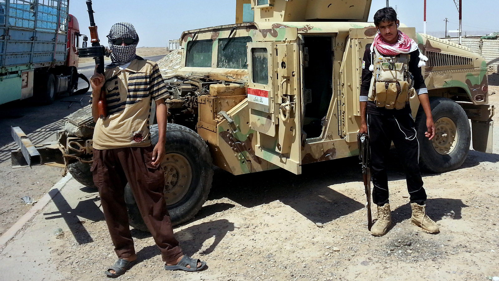 ISIS militants stand with a captured American Humvee, given to the Iraqi Army and captured by ISIS, June 19, 2014. (AP Photo)