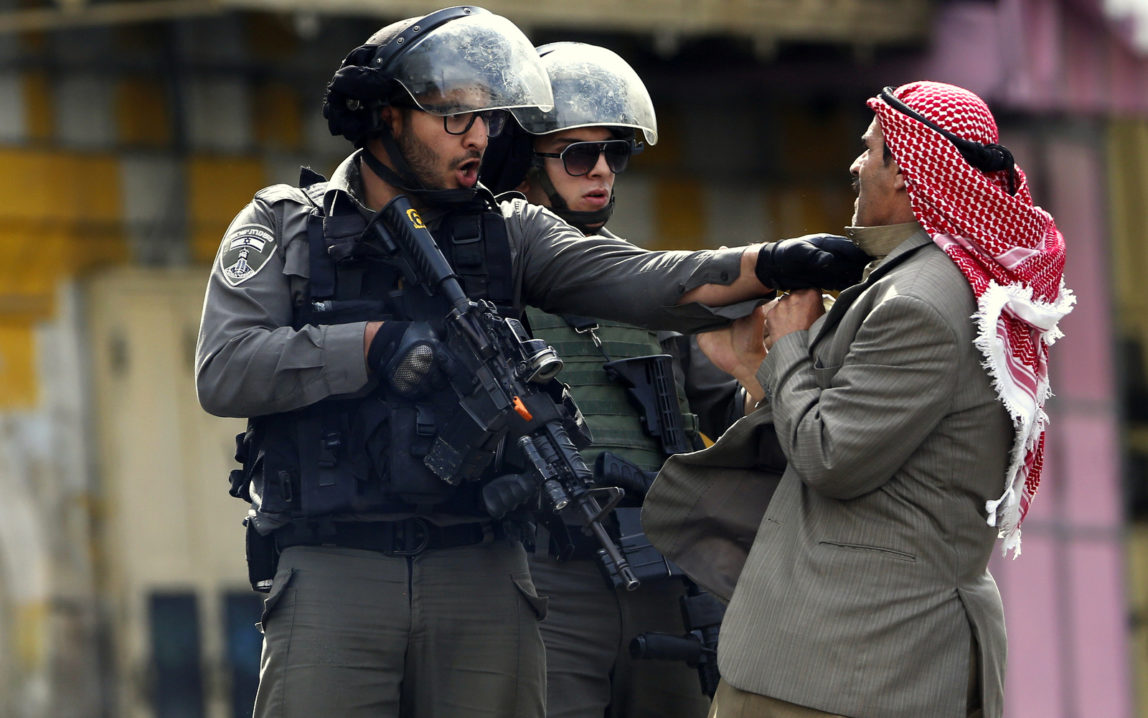 A Palestinian is pushed an Israeli policemen. Saturday, Oct. 10, 2015. (AP Photo/Nasser Shiyoukhi)