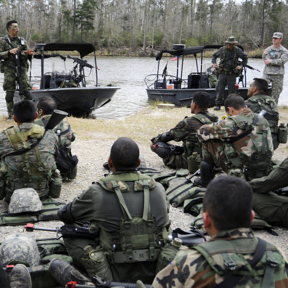 A guest instructor debriefs students from the Western Hemisphere Institute for Security Cooperation and Naval Small Craft Instruction and Technical Training School after a field training exercise. (U.S. Navy photo)