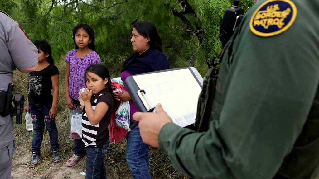 A family unit and unaccompanied minors encountered by Border Patrol Agents and Texas Game Wardens, wait as paper work is filled out. Wednesday, April 8, 2015.